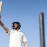 Young cricketer in Ranchi holding a cricket bat raised high, ready to play or celebrate during practice
